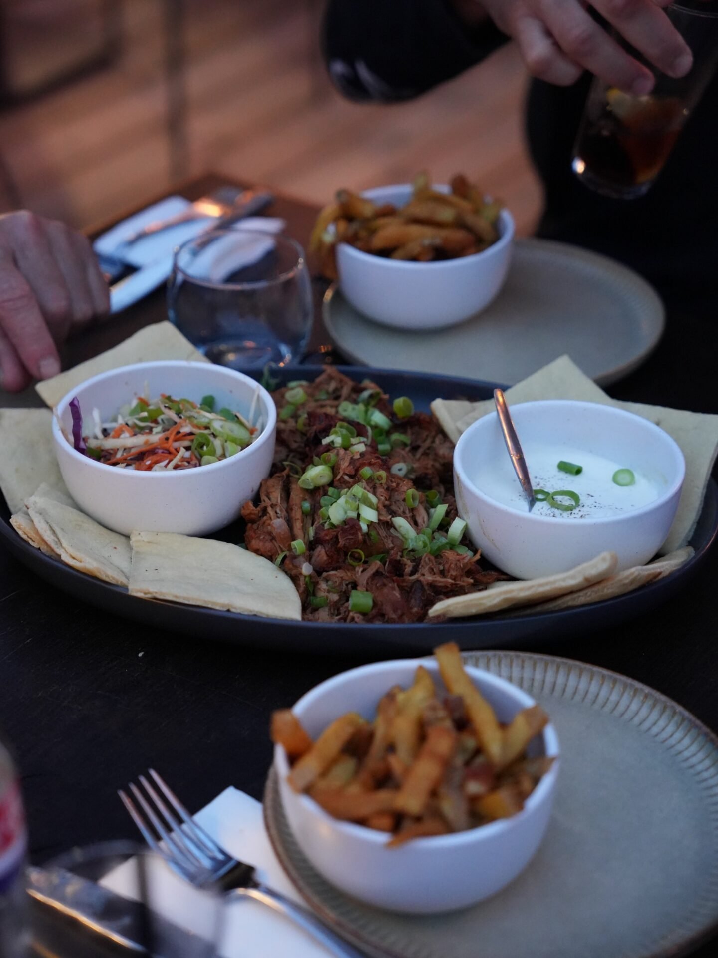Échine de porc confite à partager, vue du dessus, coleslaw et pains pita